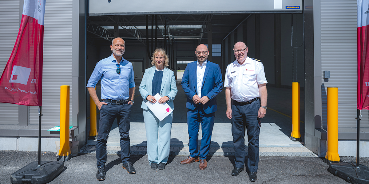 Besuch des Katastrophenschutzwarmlagers (v. l. n. r.): Sven Stolpe (BLB), Gerit Fischer (BLB), René Wilke (Innenminister), Heinz Rudolph (LSTE) Vier Personen stehen vor einem geöffneten Hallentor und lächeln in die Kamera.
