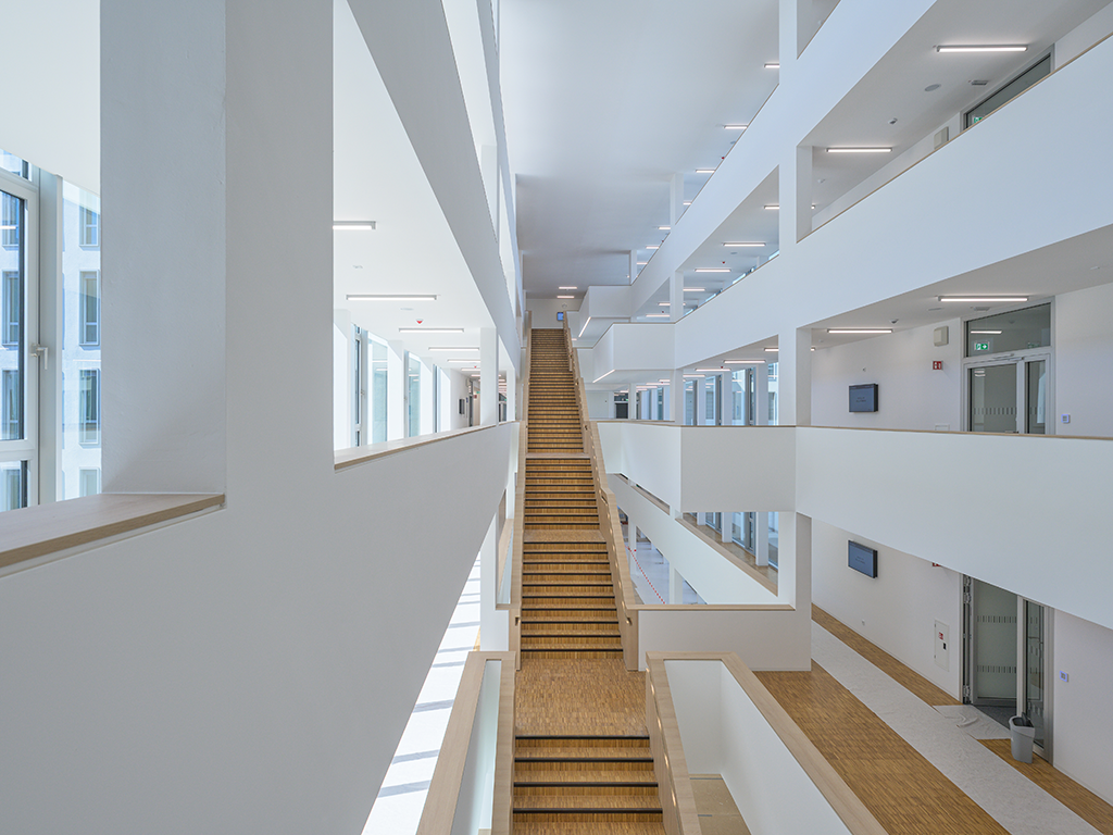 Bild: Inszenierung der zentralen Treppenflucht. Weiße Wände, Treppe aus Holz.