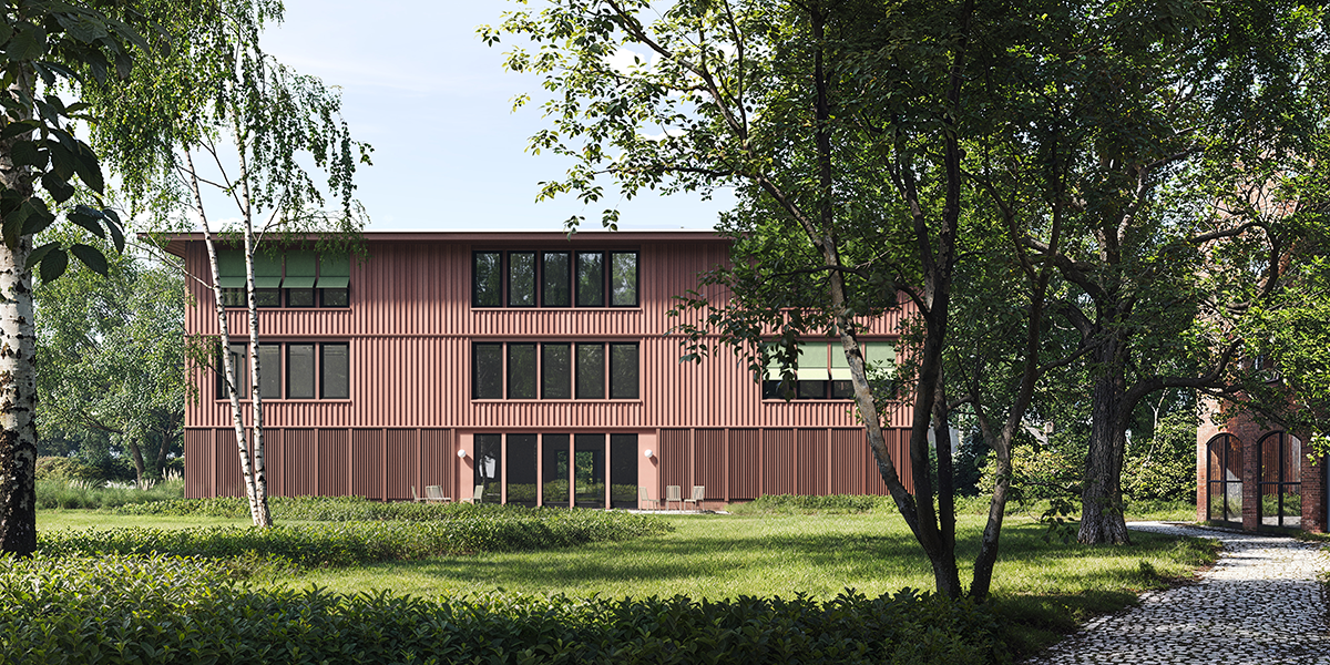 Frontansicht des neuen Gebädues mit Erdgeschoss und zwei Etage. Fassade besteht aus roten Lamellen und großen Fensterfronten. Das Gebäude ist umgeben mit viel grün und Baumbestand.