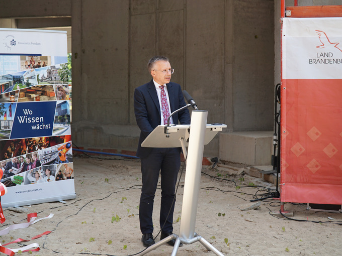 Ein Mann im dunklen Anzug steht am Rednerpult. 