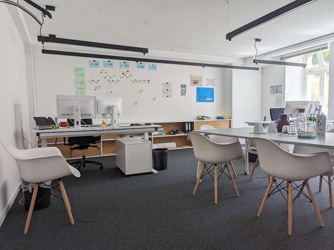 Blick in einen hellen und modernisierten Büroraum. Dieser ist mit modernen Möbeln ausgestattet.